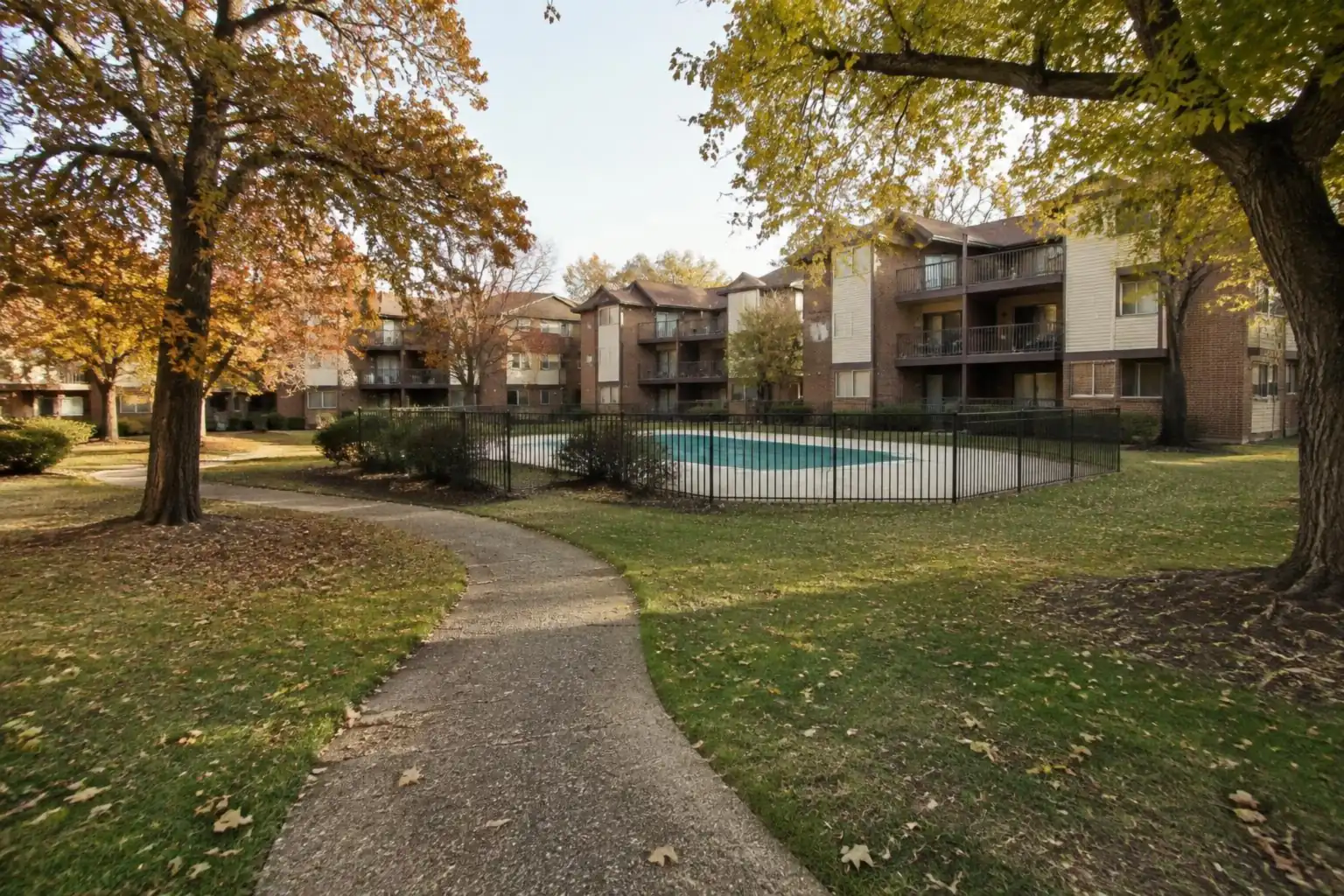 Windhaven Palatine condo buildings: three-story 1970s brick buildings around a lawn and a fenced pool