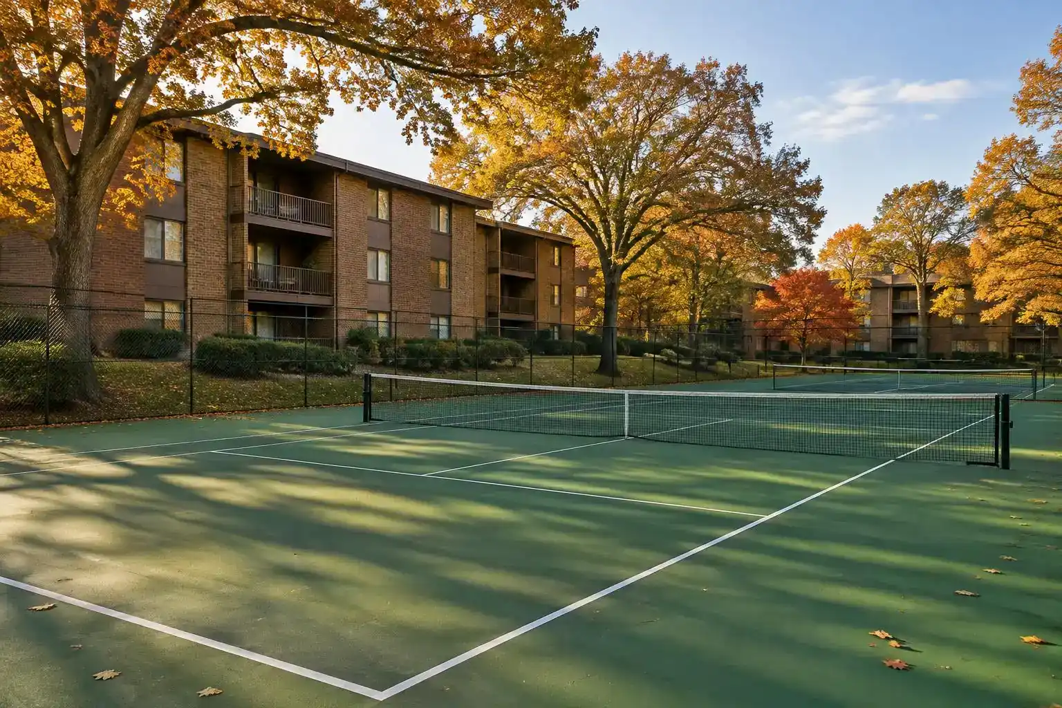 Community tennis courts beside brick condo buildings at Windhaven in Palatine, IL